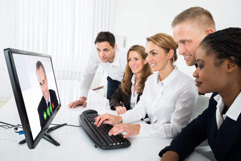 Group Of Multiracial Businesspeople Videoconferencing On Computer In Office