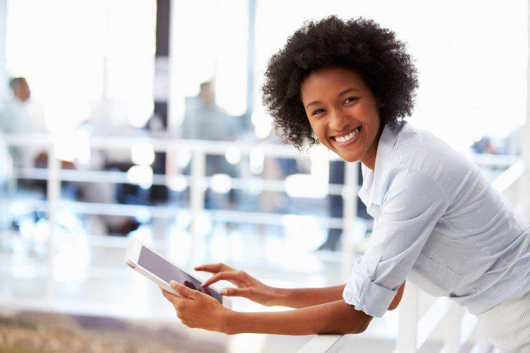 Portrait of smiling woman in office with tablet
