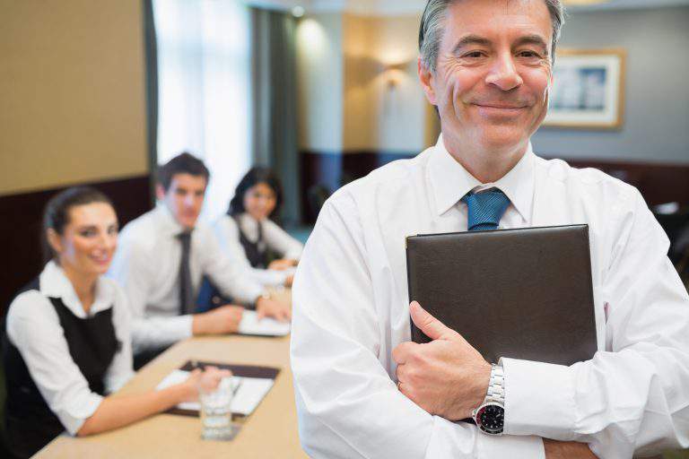18120116 - businessman holding folder at conference standing and smiling